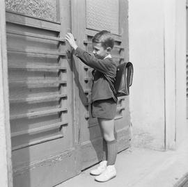 Chłopiec otwierający drzwi do szkoły